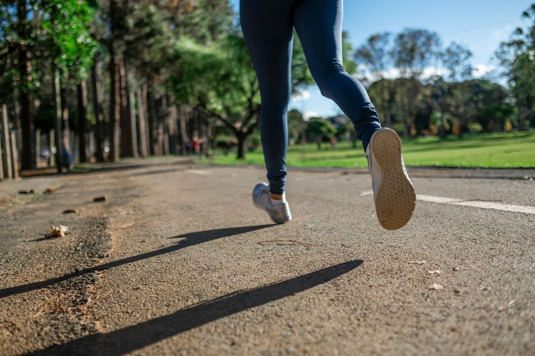 A person running on a paved road, demonstrating the importance of non-slip shoes for safety and stability.
